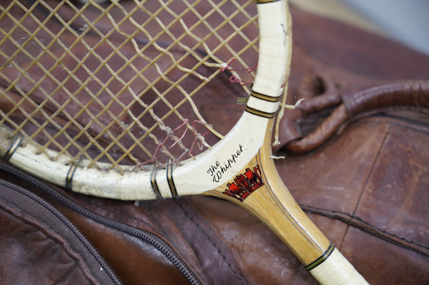 A leather sports holdall, with squash racket. Condition - poor to fair